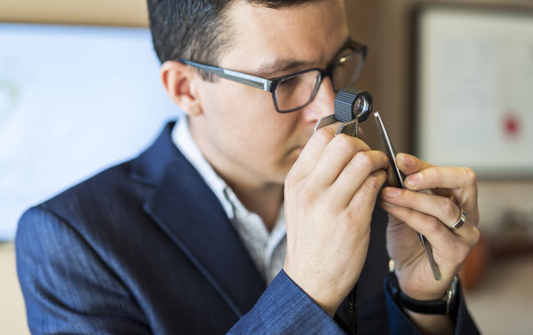 jeweler examining diamond with loupe